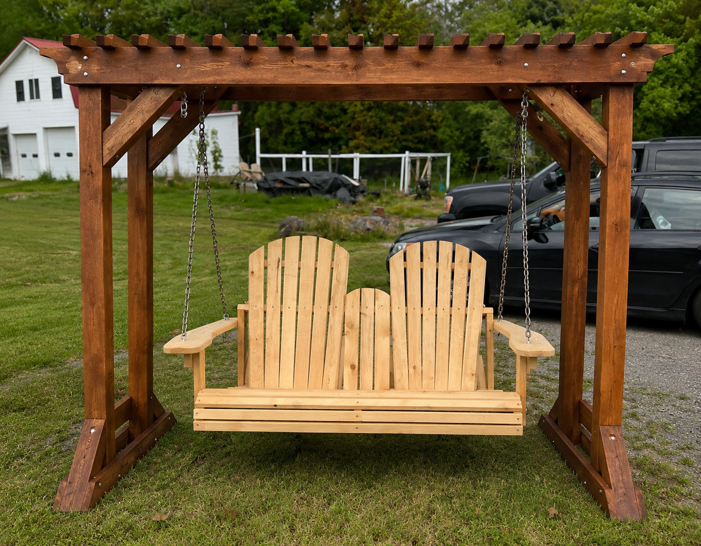 A handmade cedar porch swing hanging on a covered porch